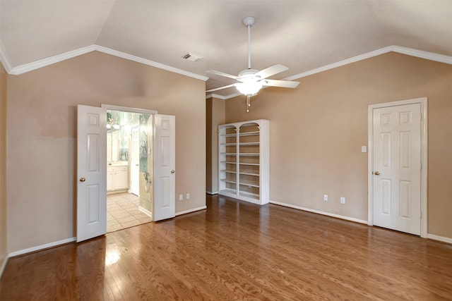 spare room with a ceiling fan, wood finished floors, visible vents, baseboards, and lofted ceiling