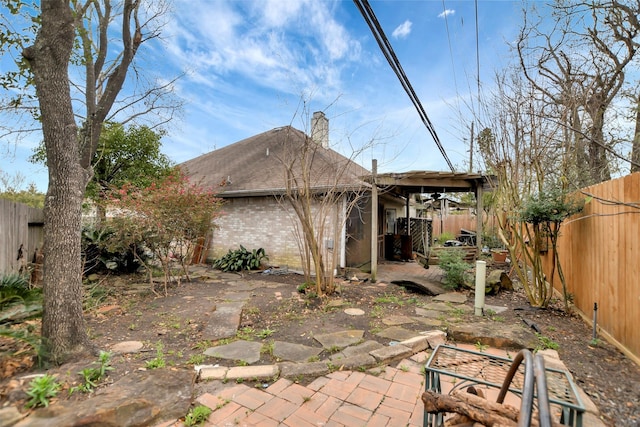 back of property featuring a patio, a chimney, and a fenced backyard