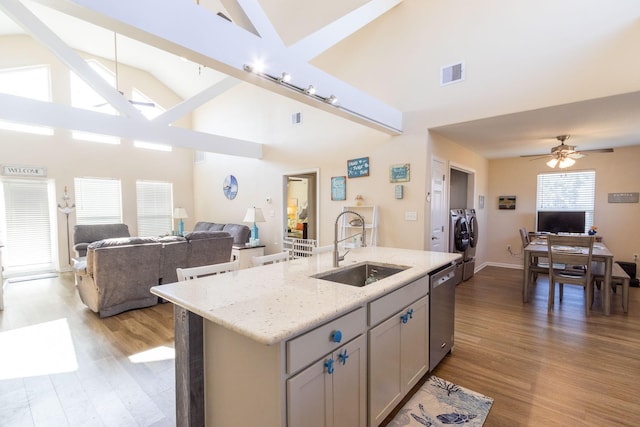 kitchen with visible vents, separate washer and dryer, a sink, stainless steel dishwasher, and open floor plan