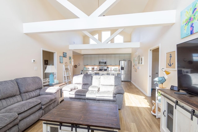 living room featuring beam ceiling, high vaulted ceiling, light wood-type flooring, and baseboards