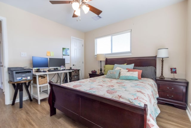 bedroom featuring visible vents, baseboards, light wood-style floors, and a ceiling fan