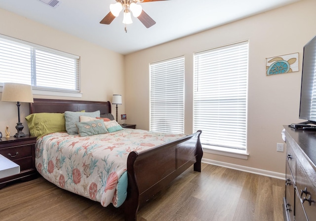 bedroom with wood finished floors, baseboards, and ceiling fan