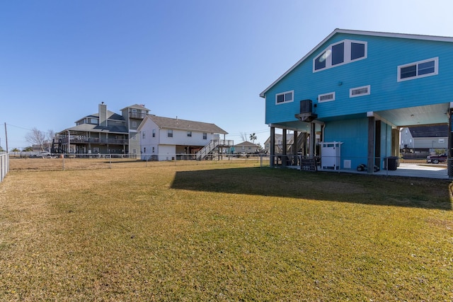 rear view of property with stairway, a lawn, central air condition unit, and fence