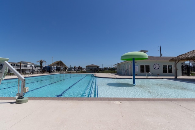 pool with a patio and fence