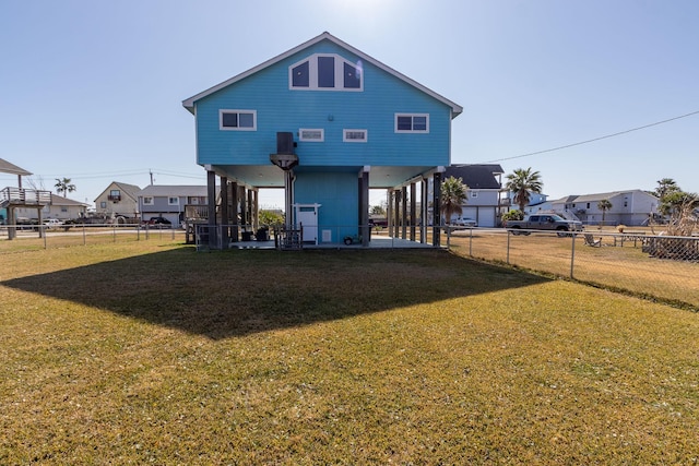 rear view of house with a residential view, a lawn, and a fenced backyard