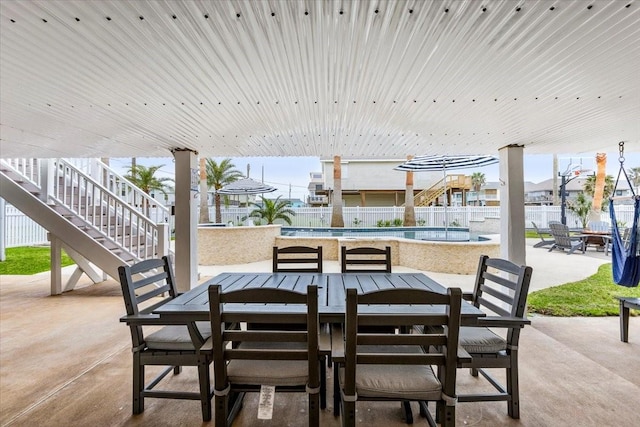 view of patio / terrace with outdoor dining space, a community pool, and fence