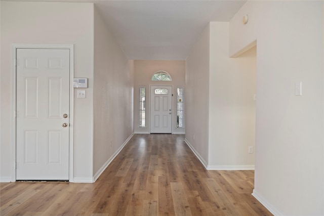 foyer entrance with wood finished floors and baseboards