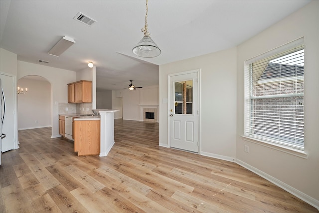 kitchen with visible vents, open floor plan, arched walkways, a peninsula, and dishwasher