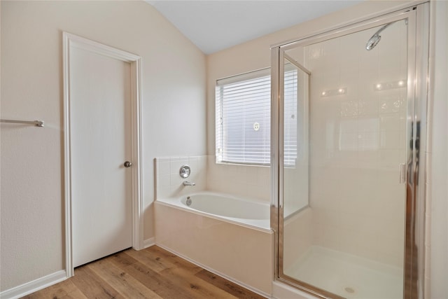 bathroom with a garden tub, wood finished floors, and a shower stall