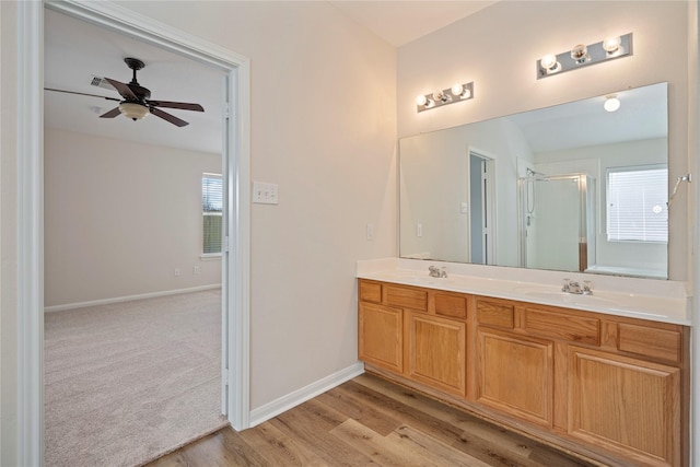 bathroom featuring plenty of natural light, a stall shower, and a sink