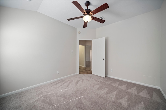 empty room with visible vents, baseboards, lofted ceiling, and carpet floors