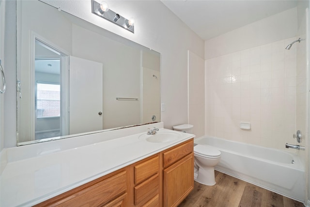 full bath featuring bathing tub / shower combination, toilet, wood finished floors, and vanity