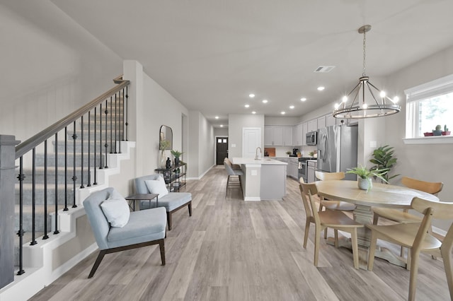 dining room featuring stairway, visible vents, light wood finished floors, an inviting chandelier, and recessed lighting