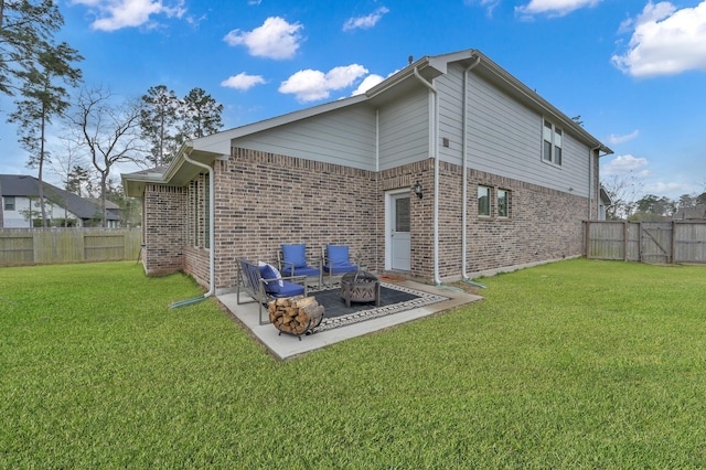 rear view of house with brick siding, a patio area, a lawn, and an outdoor fire pit