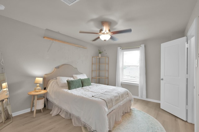 bedroom featuring visible vents, ceiling fan, baseboards, and light wood-style floors