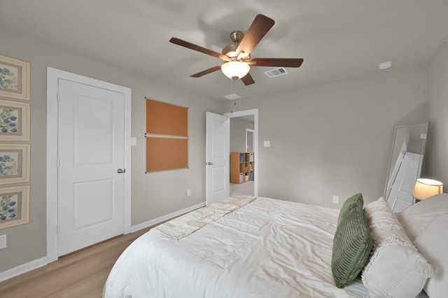 bedroom with visible vents, baseboards, light wood-style flooring, and a ceiling fan