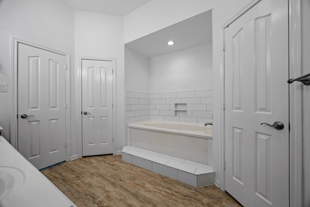 full bathroom featuring a garden tub and wood finished floors