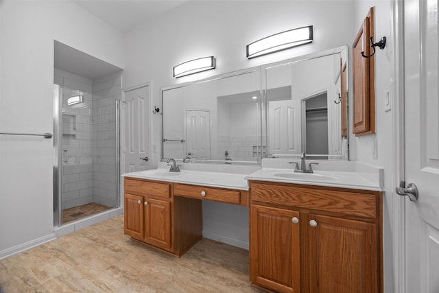 bathroom with double vanity, a stall shower, and a sink