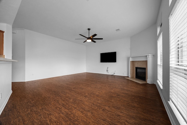 unfurnished living room featuring a ceiling fan, wood finished floors, and a tile fireplace