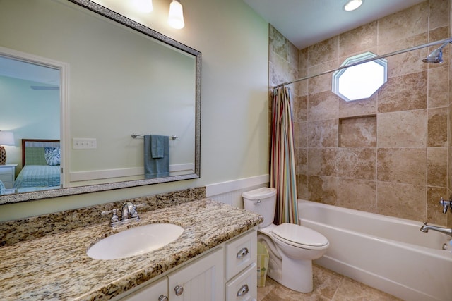 ensuite bathroom with a wainscoted wall, toilet, shower / tub combo with curtain, ensuite bath, and vanity