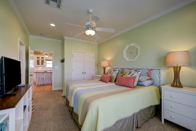 bedroom with a ceiling fan, carpet, visible vents, a closet, and crown molding