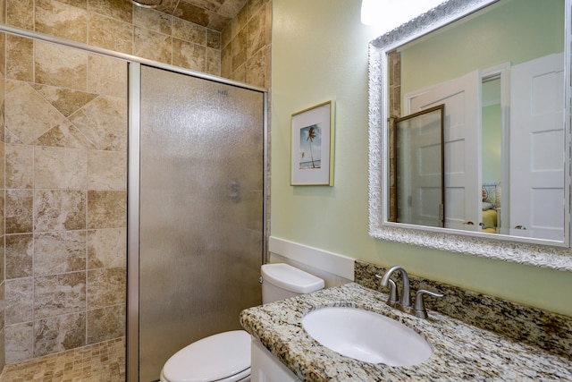 bathroom featuring vanity, toilet, and a shower stall