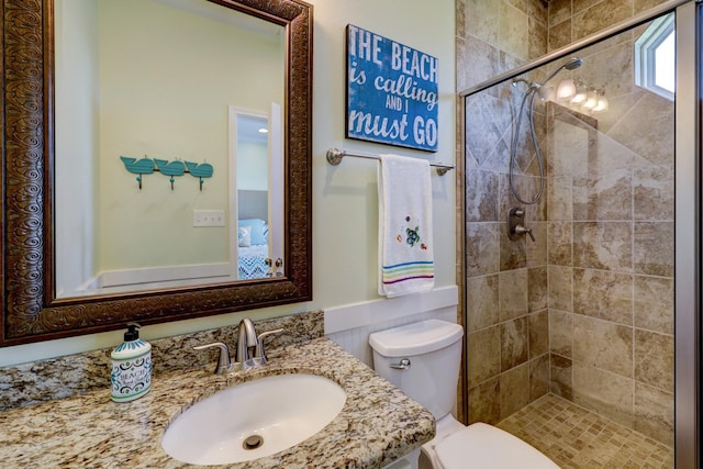 bathroom with a stall shower, toilet, and vanity