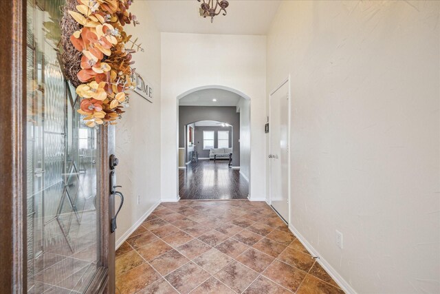 entryway featuring baseboards and arched walkways