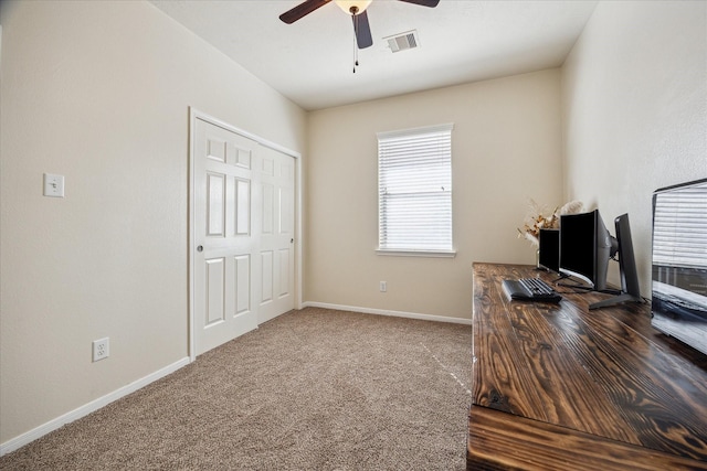 carpeted office space featuring visible vents, baseboards, and ceiling fan