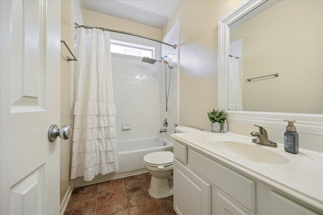 full bathroom with vanity, shower / tub combo, and toilet