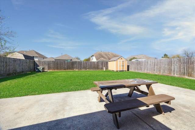 view of patio with an outdoor structure, outdoor dining area, a fenced backyard, and a shed