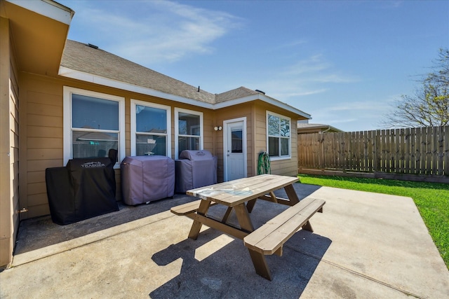 view of patio with area for grilling, outdoor dining space, and fence