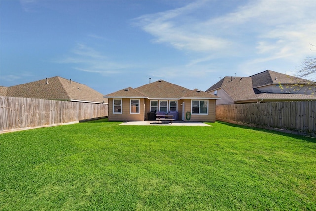 back of house with a fenced backyard, a lawn, and a patio