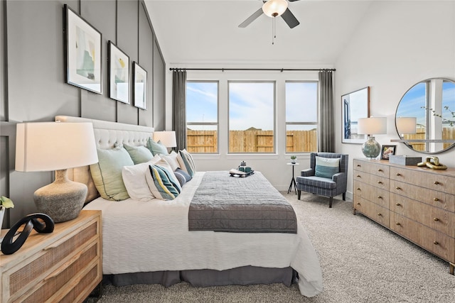 bedroom with light carpet, a ceiling fan, and vaulted ceiling