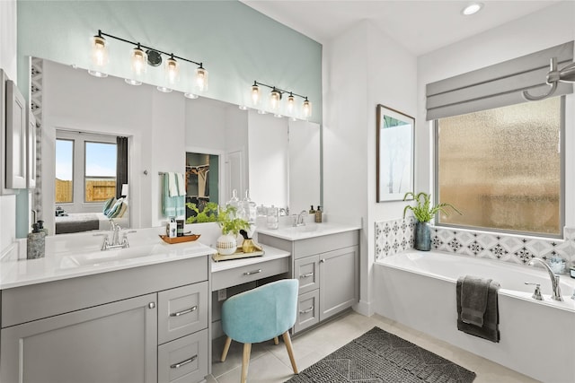 bathroom featuring a garden tub, two vanities, a sink, ensuite bathroom, and tile patterned floors