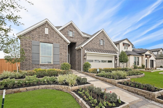 view of front facade with a front lawn, an attached garage, fence, and brick siding