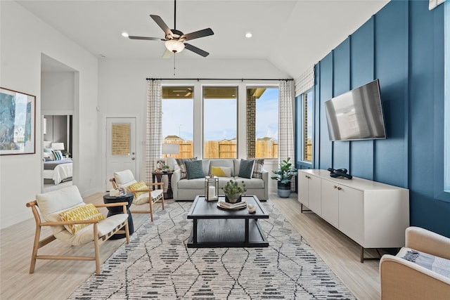 living room with baseboards, lofted ceiling, recessed lighting, ceiling fan, and light wood-type flooring