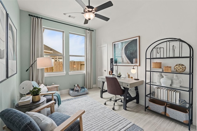 home office featuring visible vents, baseboards, wood finished floors, and a ceiling fan