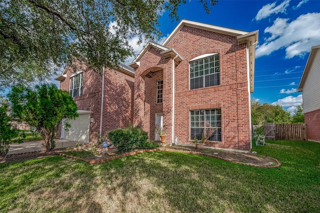 traditional-style home with brick siding, fence, concrete driveway, a front yard, and a garage