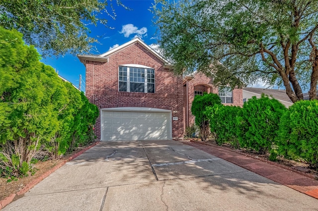 traditional-style house with concrete driveway, a garage, and brick siding