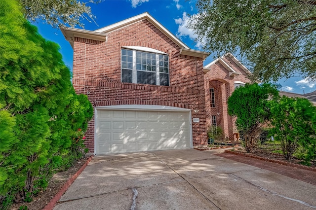 traditional-style home with concrete driveway, a garage, and brick siding