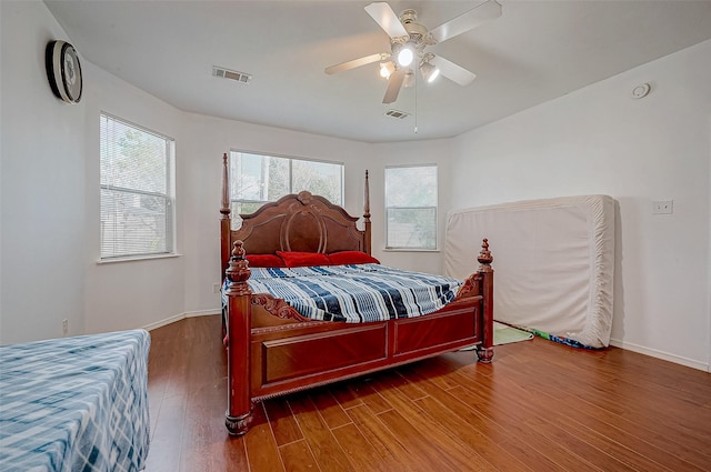 bedroom with baseboards, visible vents, wood finished floors, and ceiling fan