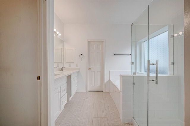 full bath featuring a garden tub, vanity, and a shower stall