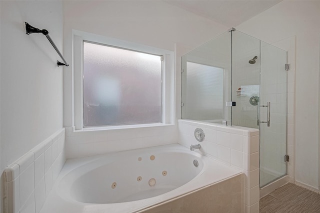 bathroom with a stall shower and a jetted tub