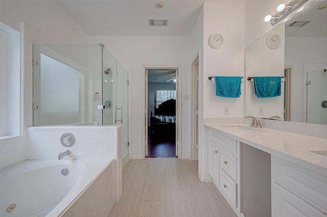 bathroom featuring visible vents, a shower stall, a garden tub, and a sink