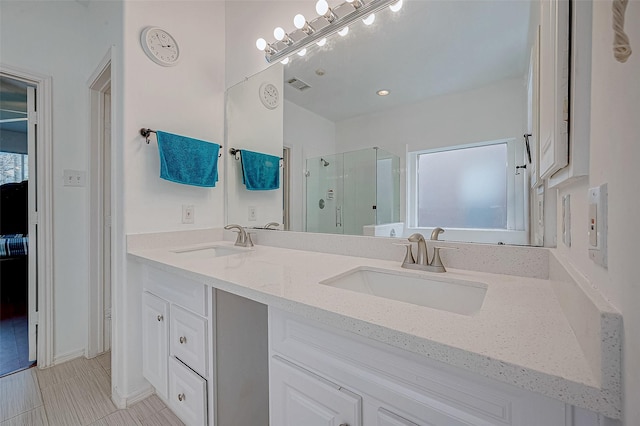 full bathroom with a stall shower, double vanity, a sink, and visible vents