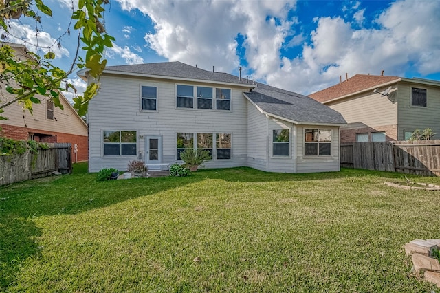 rear view of property with a lawn and a fenced backyard