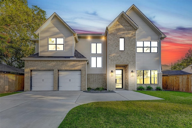 view of front facade with a lawn, fence, concrete driveway, a garage, and brick siding