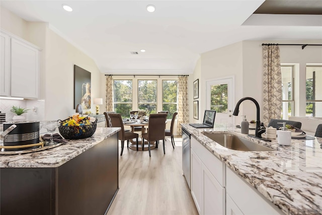 kitchen featuring light stone countertops, recessed lighting, a sink, white cabinets, and light wood-style floors