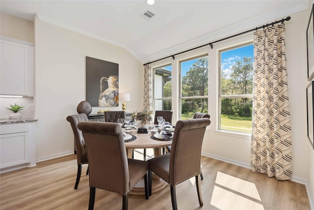 dining area featuring visible vents, lofted ceiling, light wood-type flooring, and baseboards